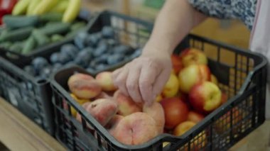 In a grocery store, the seller puts and selects fruits in a bag, for the buyer, slow motion. High quality 4k footage