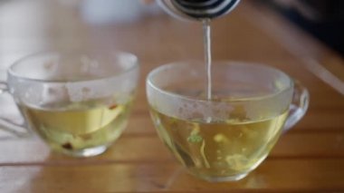 Bir kadın termostan bitki çayı dolduruyor, yakın çekim, yavaş çekim. Yüksek kalite 4k görüntü