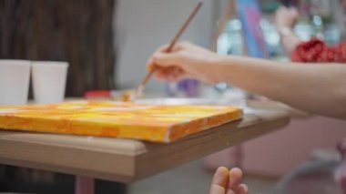 Resim için el ve fırça, yakın plan, boyalı tuval, yüksek kalite 4K görüntü.