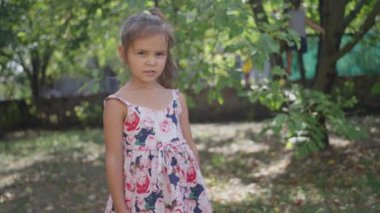 Küçük, güzel bir kız, elbise giymiş, koşuyor, gülümsüyor. Gülüyor. Ağır çekim. Yüksek kalite 4k görüntü