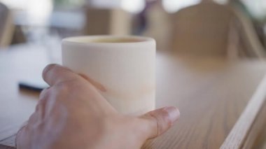 Yakın çekim, el bir fincan sıcak matcha alır, yavaş çekim. Yüksek kalite 4k görüntü