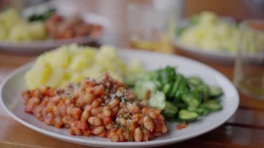 Masada fasulye, patates ve salata var. Yakın plan. Ağır çekim, vejetaryen. Yüksek kalite 4k görüntü