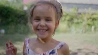 Küçük, güzel bir kız, elbise içinde, babasıyla buluşmak için koşuyor, gülümsüyor. Gülüyor. Ağır çekim. Yüksek kalite 4k görüntü