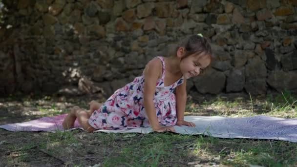 Mała Piękna Dziewczynka Bawi Się Macie Jogi Latem Ogrodzie Bawi — Wideo stockowe