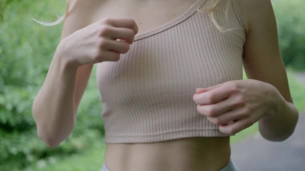 巨乳のセクシーな女の子 Tシャツを調整 スポーツトップ ブラジャー 接近中だ 高品質4K映像 — ストック動画