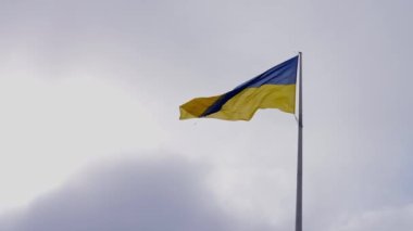 Bulutlu gökyüzüne karşı Ukrayna bayrağı. Ukrayna 'nın sarı-mavi bayrağı dalgalanıyor. Ukrayna Ulusal Sembolü. Ağır çekim. Yüksek kalite 4k görüntü