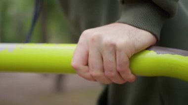 Sonbaharda antrenman, kapüşonlu adam, paralel barlarda antrenman, yavaş hareket. Yüksek kalite 4k görüntü