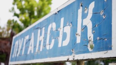 Ukrayna 'daki savaş, yakın plan, şehirlerin isimlerinin yazılı olduğu tabletler, kurşun deliklerinde, şehir plakaları Lugansk ağır çekimde vuruldu. Yüksek kalite 4k görüntü