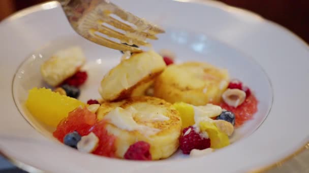 チーズケーキ ラズベリーとブルーベリーのシンキ クローズアップ フォークで手 スローモーション 高品質4K映像 — ストック動画