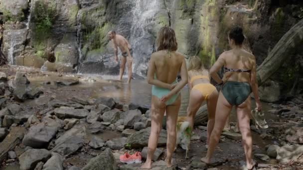 Жінки Купальниках Спостерігають Мачо Чоловіка Розслабляються Плавають Біля Красивого Водоспаду — стокове відео
