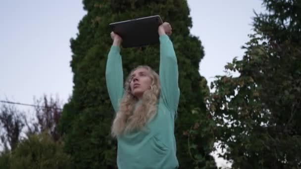 Blondi Nainen Joka Käyttää Kannettavaa Tietokonetta Puutarhassa Illalla Tekee Harjoituksia — kuvapankkivideo