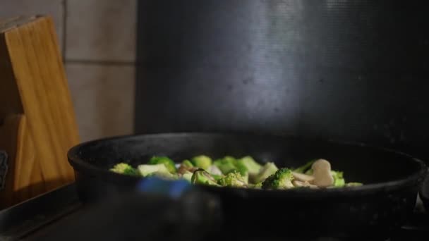 女性は鍋にキノコとブロッコリーを調理し ガスストーブの上で食べ物を調理し クローズアップします 高品質4K映像 — ストック動画