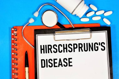 Hirschsprung hastalığı. Tıbbi teşhisi olan bir klasörde steteskop ve ilaçların arka planına yazılmış bir yazı..
