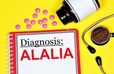 Alalia. Tıbbi teşhis klasöründeki yazı, steteskop ve ilaçların arka planına karşı..