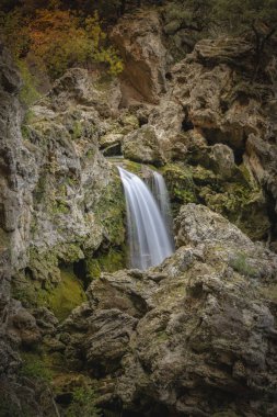 Sierra de Cazorla, Jan, İspanya Doğal Parkı 'nda büyülü atmosferi olan kayaların doğal ortamında güzel bir şelalenin dikey fotoğrafı.