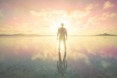 Murcia bölgesindeki Mar Menor 'un sakin sularının renkli ve pembe günbatımında bir adamın silueti.