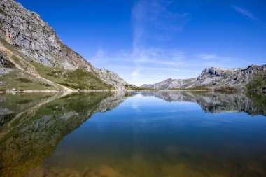 İspanya 'nın Asturias kentindeki Somiedo Doğal Parkı' nda Lago del Valle. Dağların bir ayna gibi gölde yansıtıldığı bir rüya ortamı. Doğa, doğa yürüyüşü ve turizm için en saf halindedir..