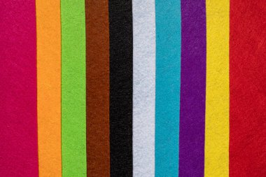 Gökkuşağını taklit eden çeşitli renklerin şeritlerini hissettim. El sanatları için okul malzemeleri.