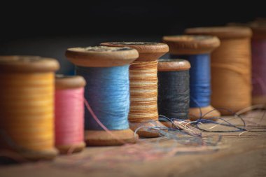 Yedi eski ahşap iplik makarası farklı renklerde retro ve klasik tarzda yumuşak zıt ışıkta