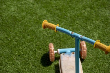 Eski ve kullanılmış metal ve plastik scooter Suni çimlerin üzerinde Güpegündüz bahçede