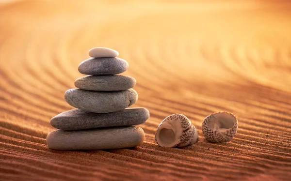 Stack of six zen stones in a relaxing sunset beach setting that invokes peace and harmony.