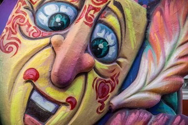 Neşeli ve renkli maskeler bir karnaval geçidinde şamandıra süslüyor.