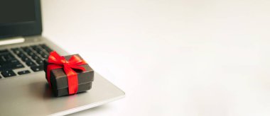 Laptopta paketlenmiş hediye kutusu. Hediye pankartı için online alışveriş. Mevsimlik satış konsepti. Boşluğu kopyala
