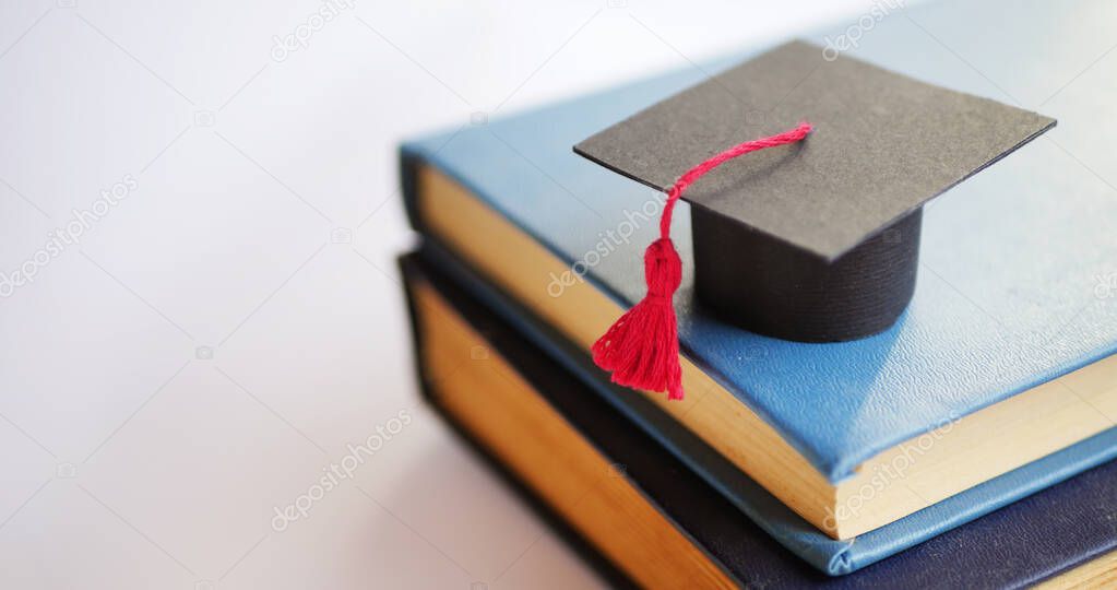 Graduation cap on stack of books. University degree concept 