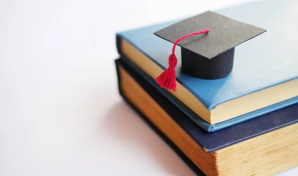 Back to school. Student cap on stack of books. Educational concept 