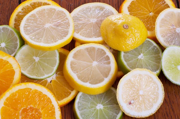 Zitronen-, Limetten- und Orangenscheiben auf einem Tisch — Stockfoto