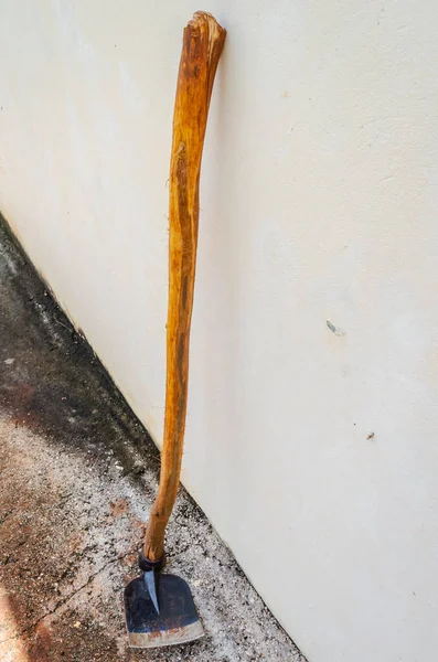 Μια Μαύρη Τσάπα Μακρύ Ξύλινο Ραβδί Ακουμπά Έναν Τοίχο Έξω — Φωτογραφία Αρχείου
