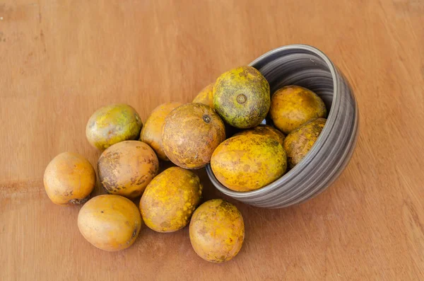 Haziran erikleriyle dolu bir kase olgun meyveleri ahşap bir yüzeye döküyor..