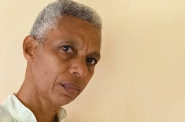 A senior woman with short trimmed black and white hair is looking sideways.