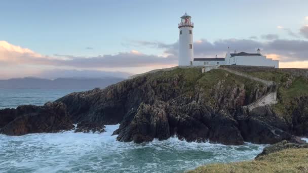 一个关于日落时海浪在爱尔兰法纳德灯塔的岩石上冲撞的视频 — 图库视频影像