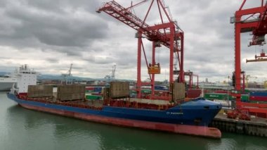 Dublin, Ireland- July 7, 2022: A container ship getting loaded by a crane in Dublin Port