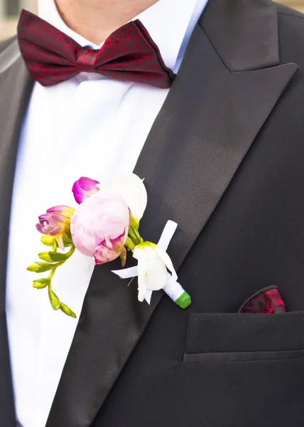 Close-up van Poeny roze bloem op bruidegom Tuxedo — Stockfoto