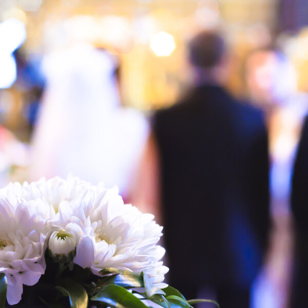 Flowers with a wedding ceremony in background