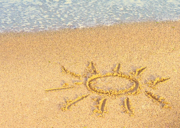 Drawing of the sun on sand with sea wave — Stock Photo, Image