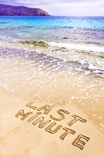 Último minuto escrito na areia, sendo lavado pelas ondas — Fotografia de Stock