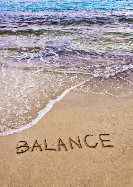 Word BALANCE written on sand, with sea waves in background — Stock Photo, Image