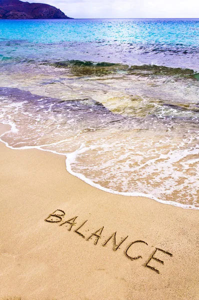 Word BALANCE written on sand, with sea waves in background — Stock Photo, Image