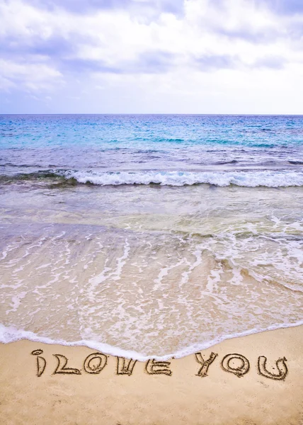 Words I LOVE YOU written on sand, with wave in background — Stock Photo, Image