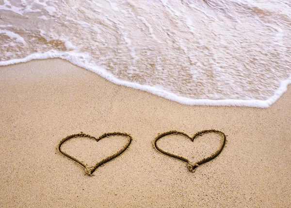 Symbols of two hearts drawn on sand, love concept — Stock Photo, Image