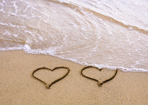 Symbols of two hearts drawn on sand, love concept — Stock Photo, Image