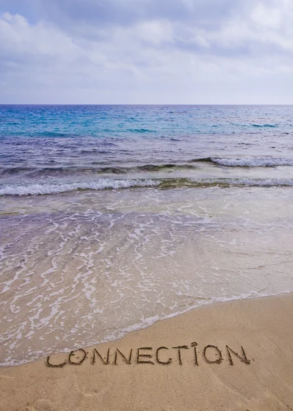 Connection word written on sand, with waves in background — Stock Photo, Image