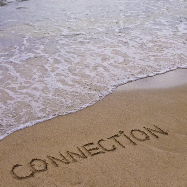 Connection word written on sand, with waves in background — Stock Photo, Image