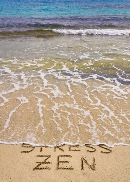 Слова Стресс и Дзен написано на песке, Стресс слово смывается волной — стоковое фото