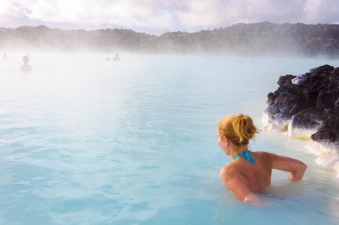 Beautiful young woman in Blue Lagoon geothermal spring , Iceland clipart