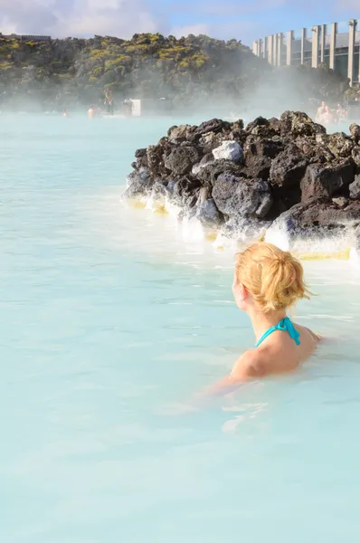 Mooie jonge vrouw in de blauwe lagune geothermische lente, IJsland — Stockfoto