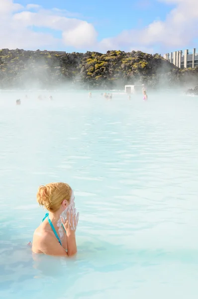 Mooie jonge vrouw in de blauwe lagune geothermische lente, IJsland — Stockfoto